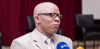 Dr Hakizimana presenting his new Christian book to believers