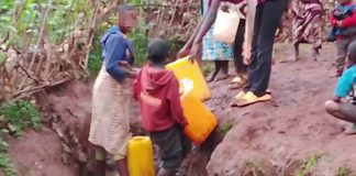 Rusizi residents walking in a village area without water and electricity.